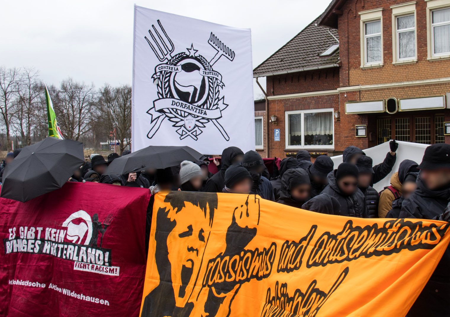 Dorfantifa-Demonstrationszug vor einer Gaststätte.